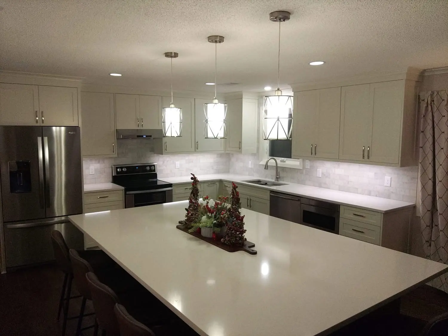 White kitchen with a long island and pendant lights